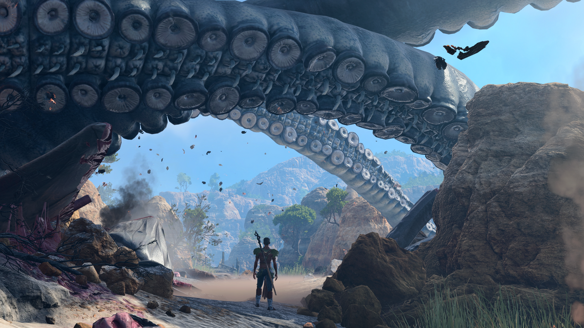 Baldur's Gate 3 character standing below a vast tentacle on a wreck-strewn shore; 2023 PC release press screenshot