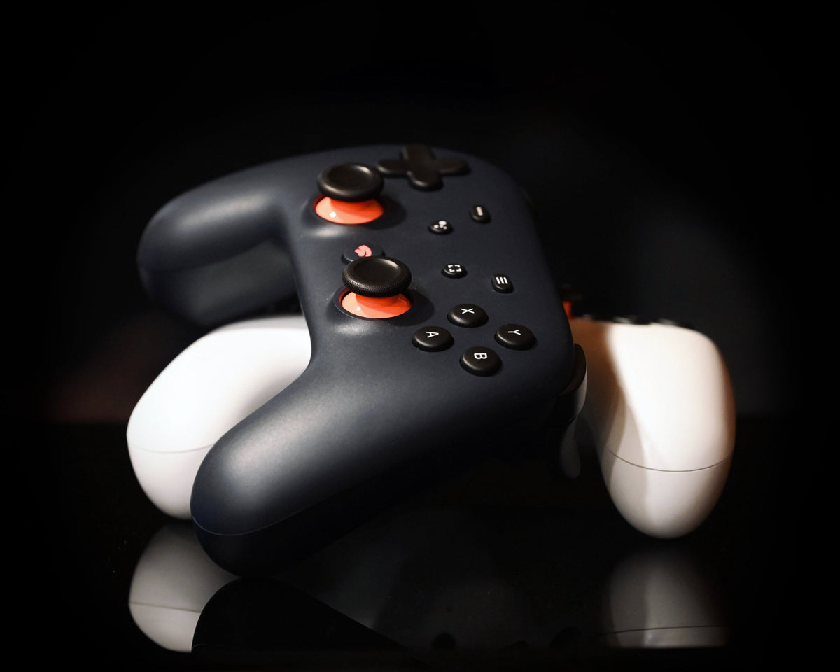 A white Google Stadia controller photographed against a dark background