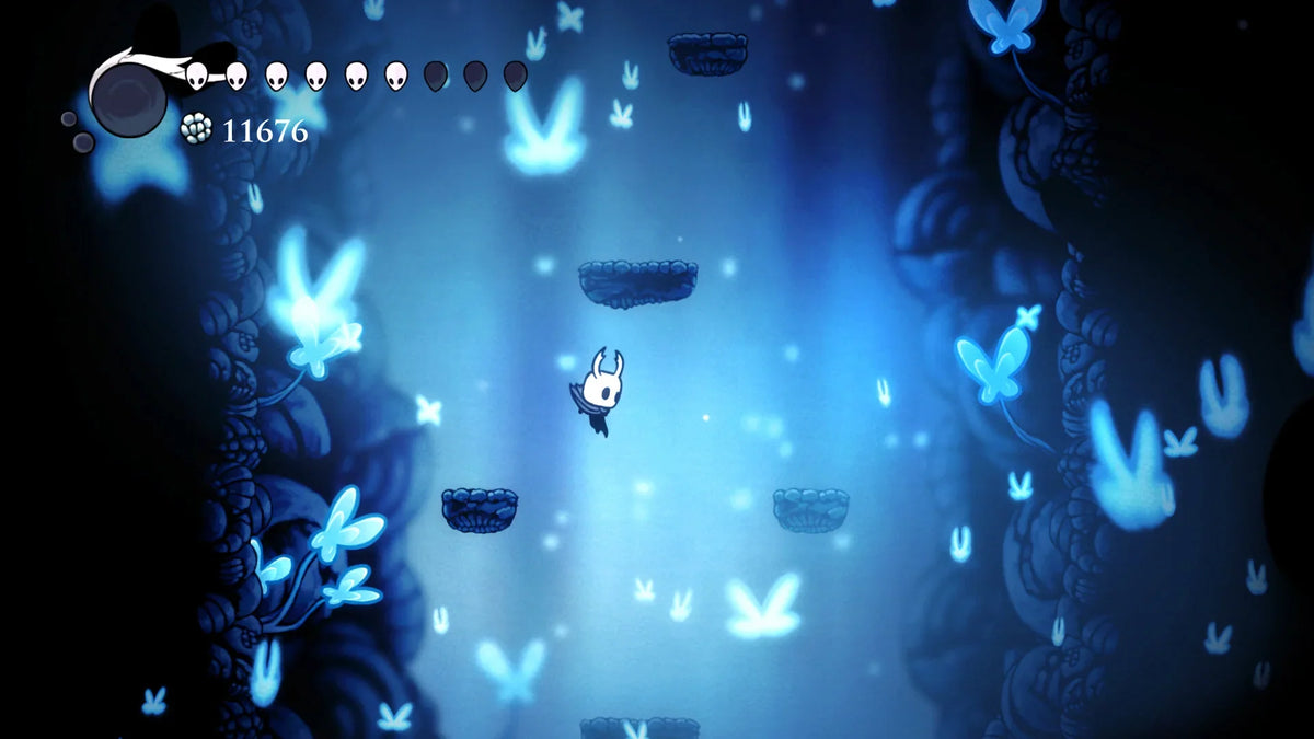 The Knight jumps between stone platforms inside a tall blue cavern filled with glowing shapes