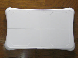 White Nintendo Wii Balance Board photographed from above on a wooden floor