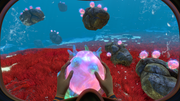 
Subnautica gameplay screenshot holding a Floater above red seagrass — official PlayStation Blog image